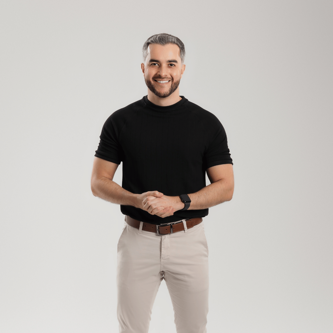 Homem sorridente de camisa preta posando de forma confiante, promovendo serviços de consultoria para obtenção de visto americano em Ipatinga.